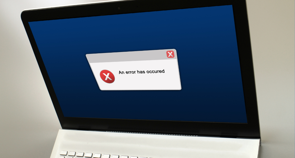 Laptop screen with a white error dialog and red 'X' showing 'An error has occurred.